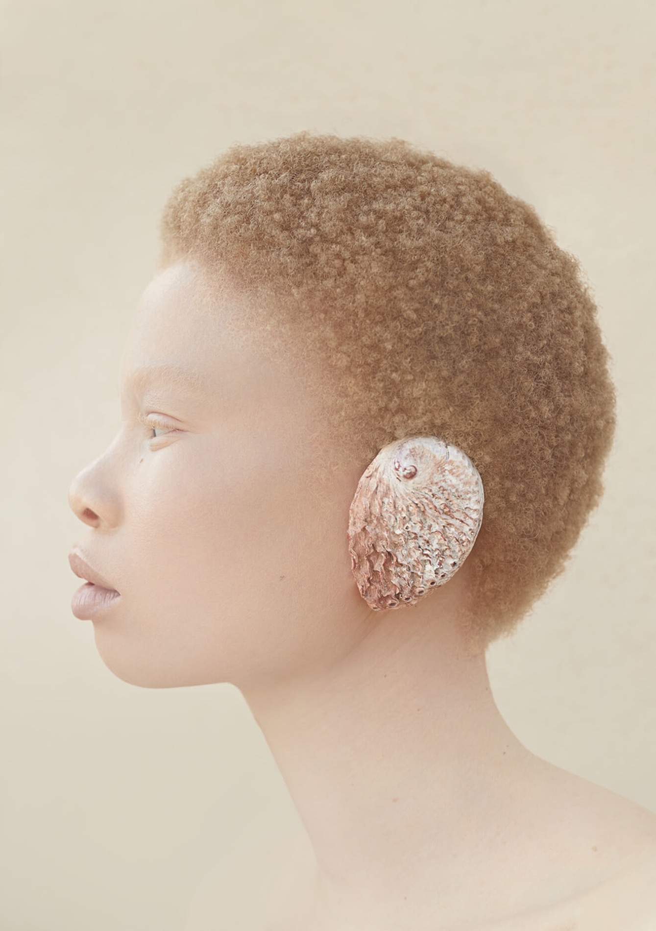 Hair editorial, apricot afro in profile with a shell ear piece